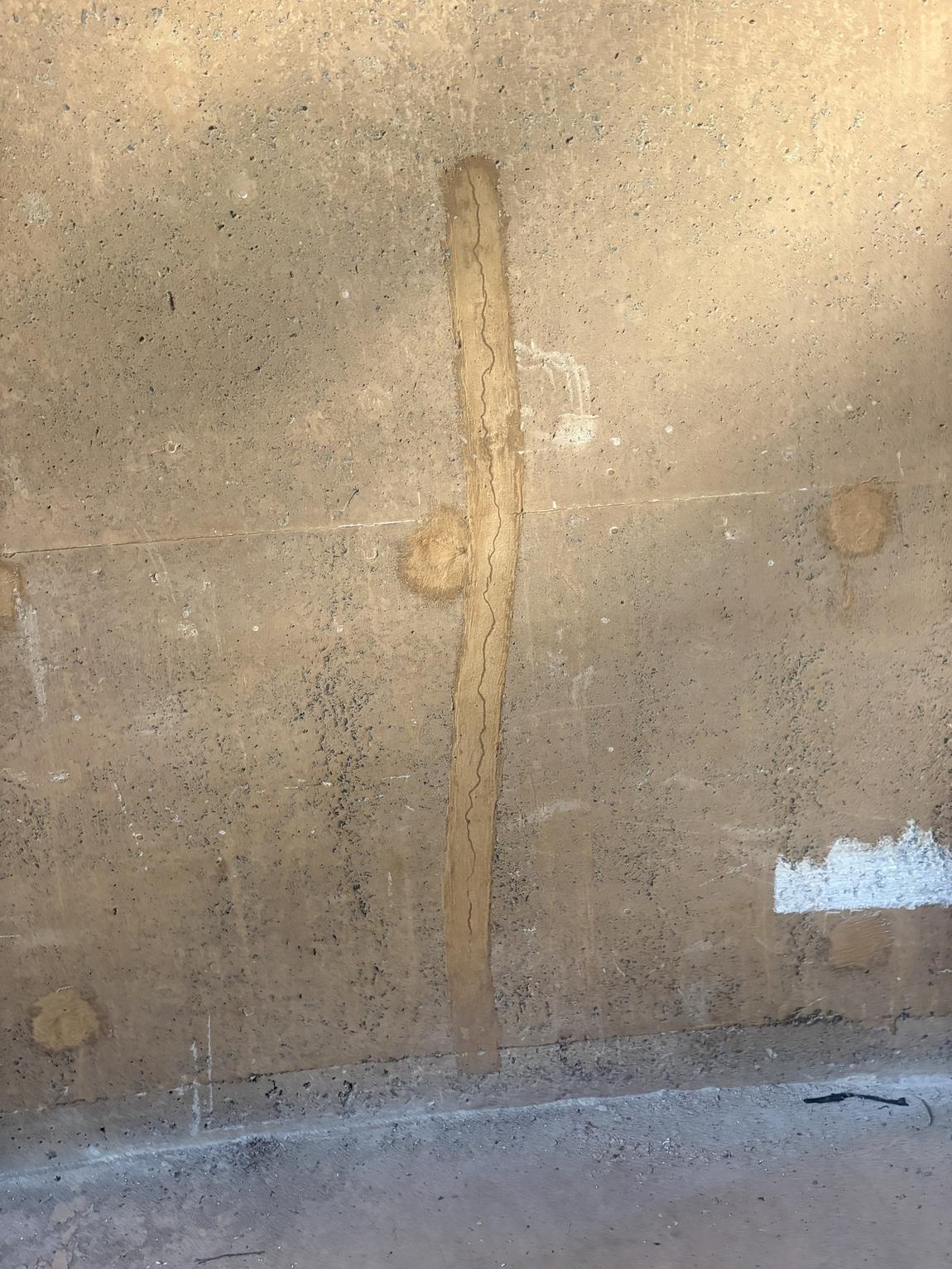 Vertical crack in the reservoir wall which has re-opened through the full length of a previous cementitious repair band.