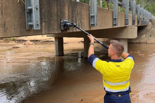 Technician conducting a GPR survey beneath Anna Creek Bridge, Burton QLD