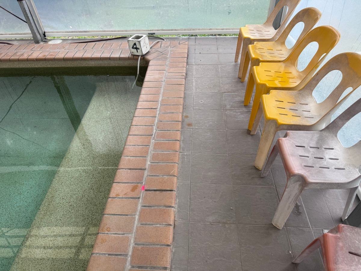 Pool coping with a crayon mark showing the reported return line leak location